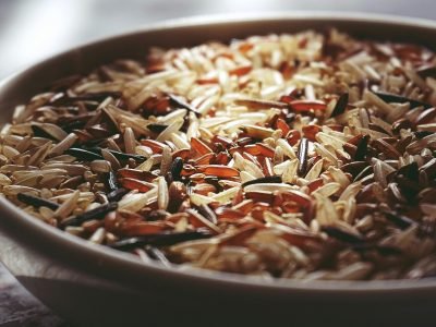 Macro shot of a ceramic bowl filled with colorful mixed wild rice, highlighting textures.